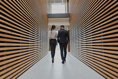 Business people walking in wood lined building corridor